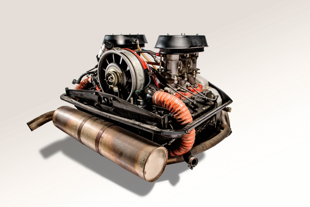 A close-up view of an air-cooled engine, featuring its distinctive cooling fan and finned components, showcasing the simplicity and engineering design characteristic of classic automotive engines.
